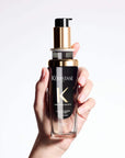Chronologiste Huile De Parfum bottle in hand, elegant hair fragrance with rose, light wood, and musk notes for nourished, shiny hair.